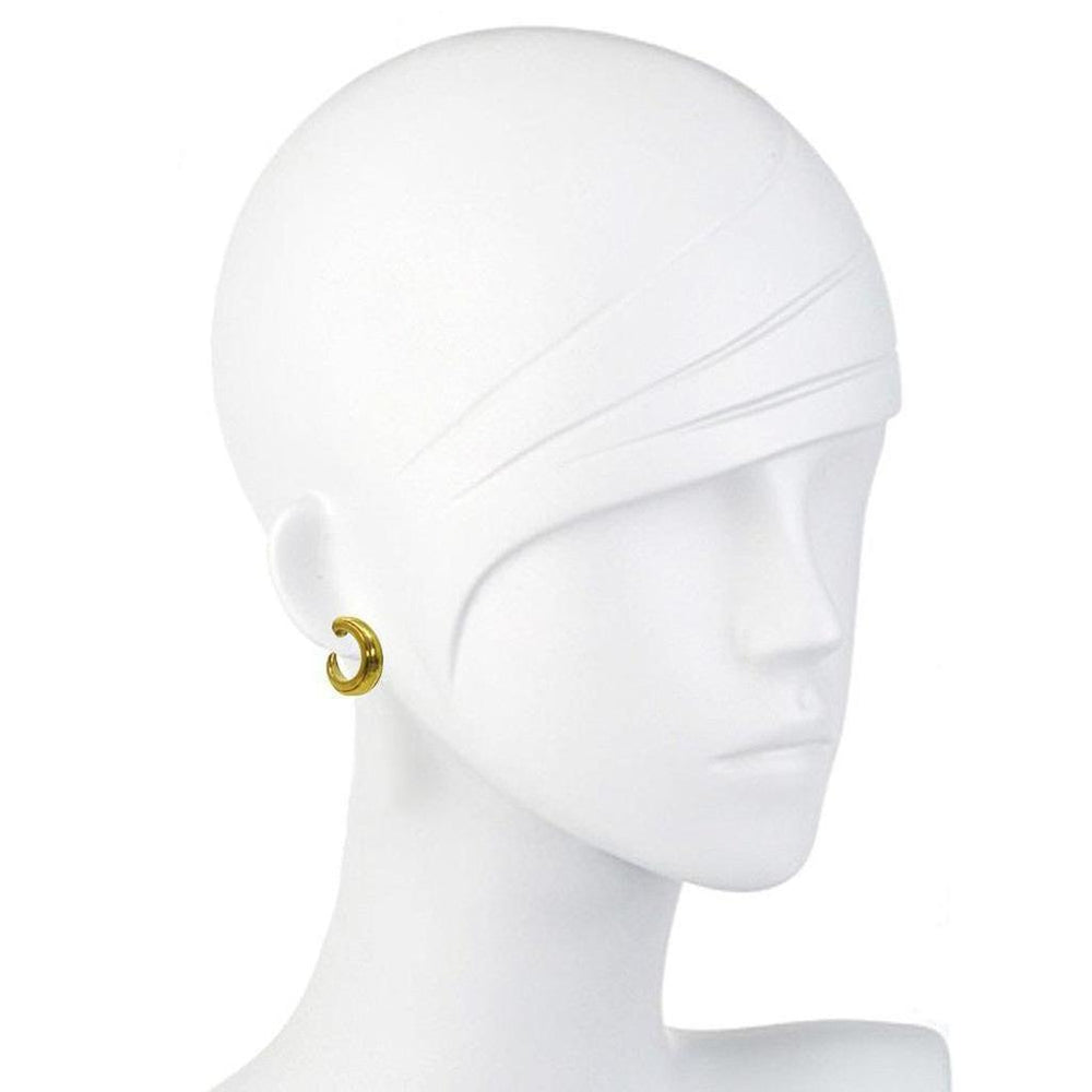 Gold hoop earrings on a mannequin.