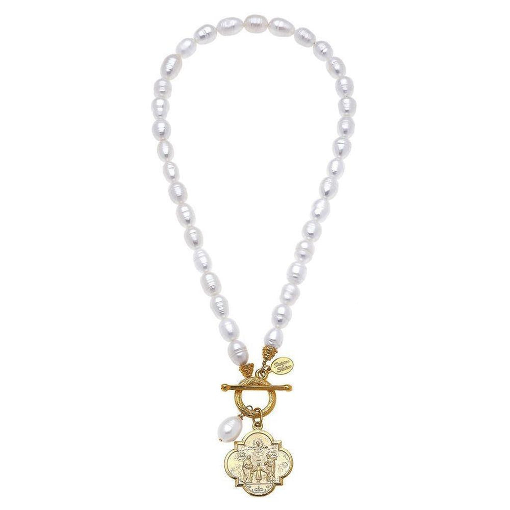 Elegant pearl necklace with gold coin pendant, featuring a detailed etched design.