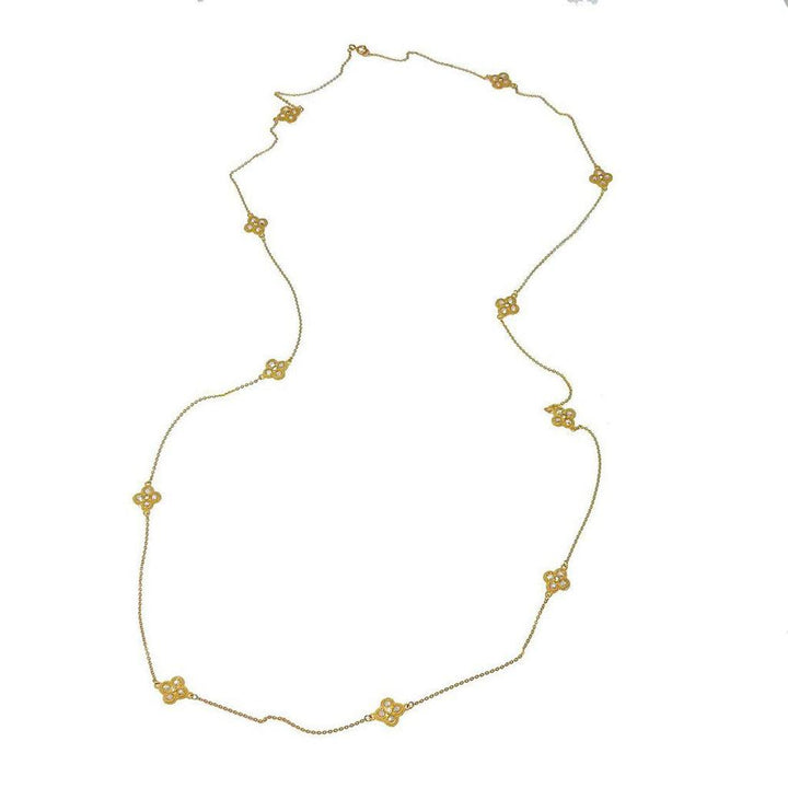 Long gold necklace with delicate clover accents and small sparkling stones.