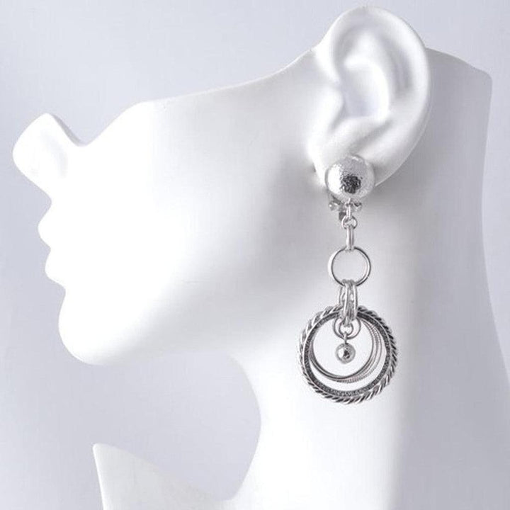 Silver clip-on earrings featuring layered textured circles and small ball accents.