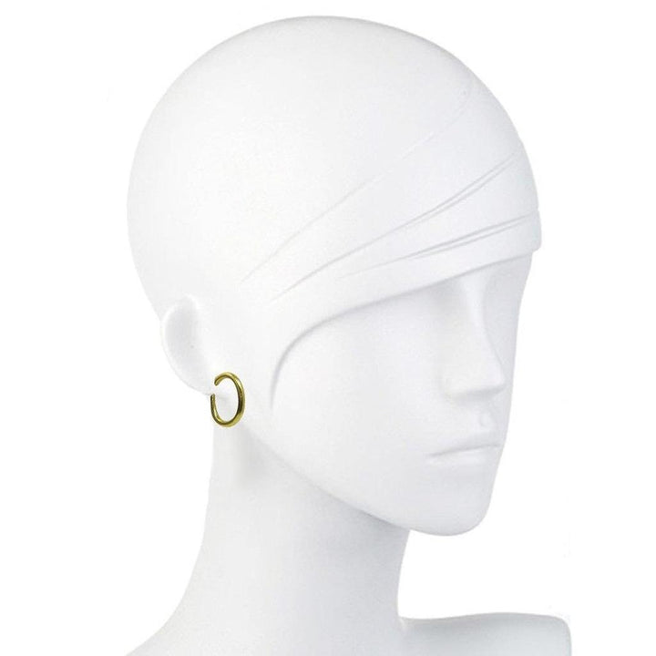 Gold oval hoop earrings on a mannequin.