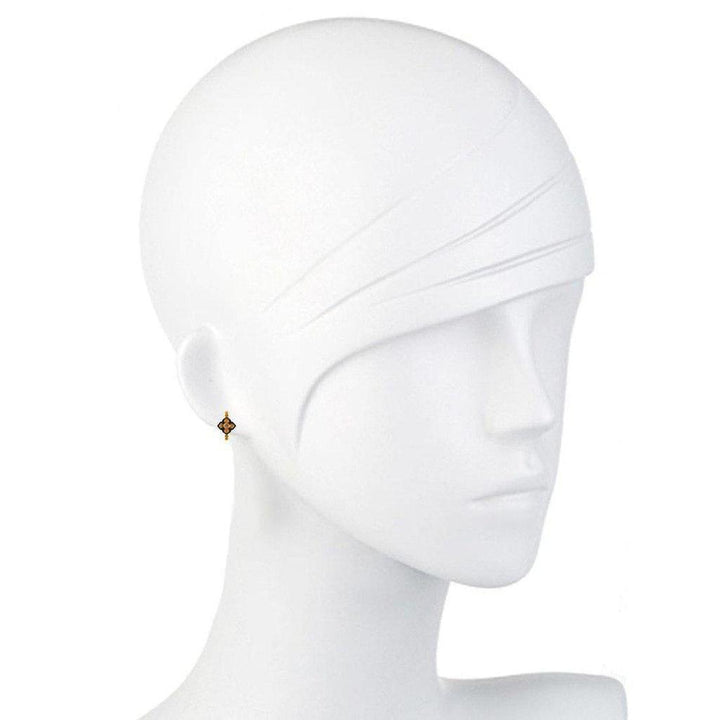 Gold vermeil hoop earrings with a small, dark centerpiece on a mannequin.