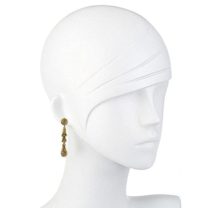 Gold teardrop earrings with textured detailing, shown on a mannequin.