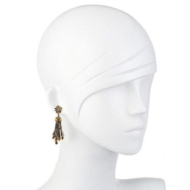 Grey beaded tassel earrings on a mannequin, showcasing detail.