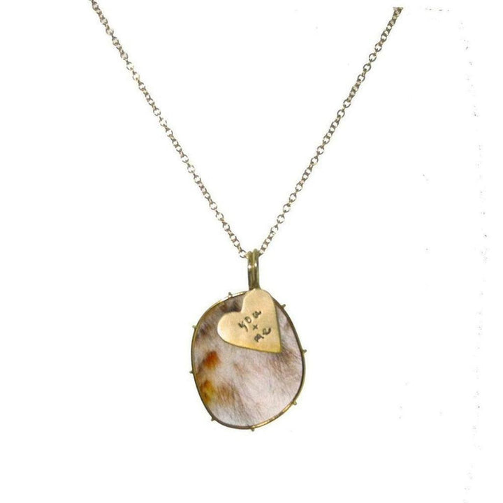 Rose gold necklace featuring a rustic, oval red rutilated quartz pendant with a small heart charm inscribed "you + me."