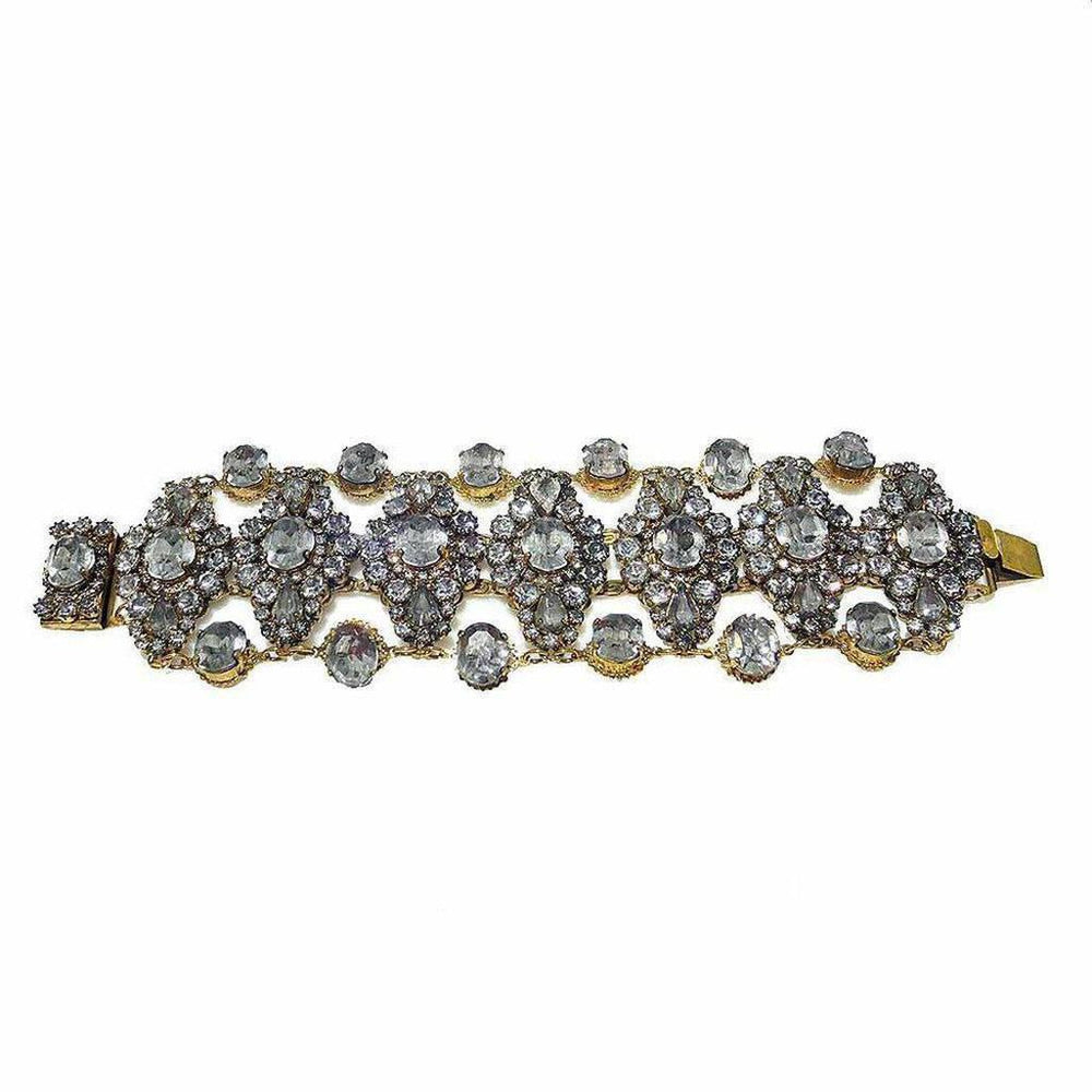 Gold bracelet adorned with sparkling clear stones, arranged in an intricate floral pattern.