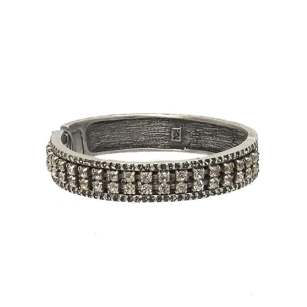 Silver hinged bangle bracelet adorned with sparkling crystal accents.