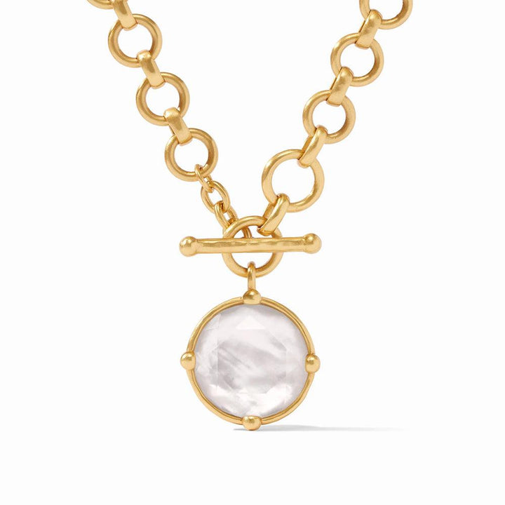 Gold toggle necklace with a large, round mother-of-pearl pendant.