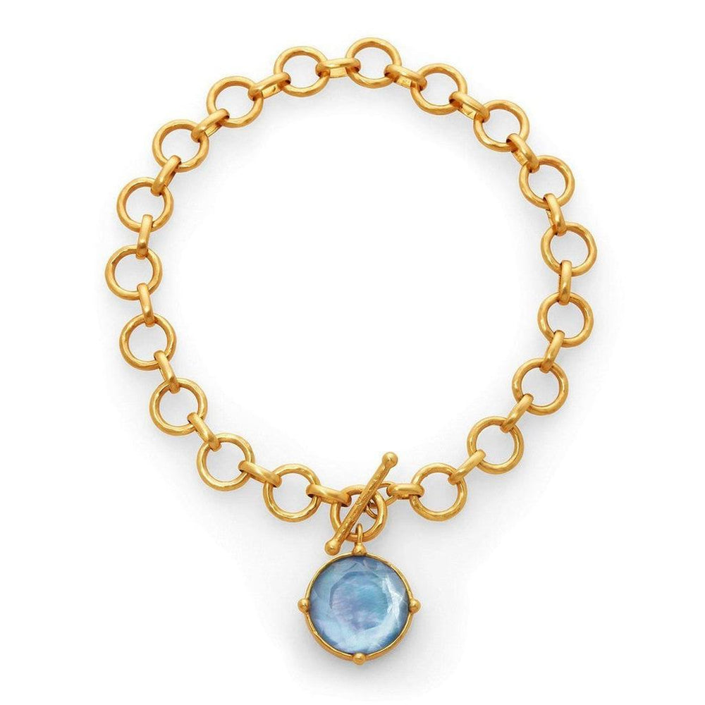 Gold chain necklace with a light blue gemstone pendant.