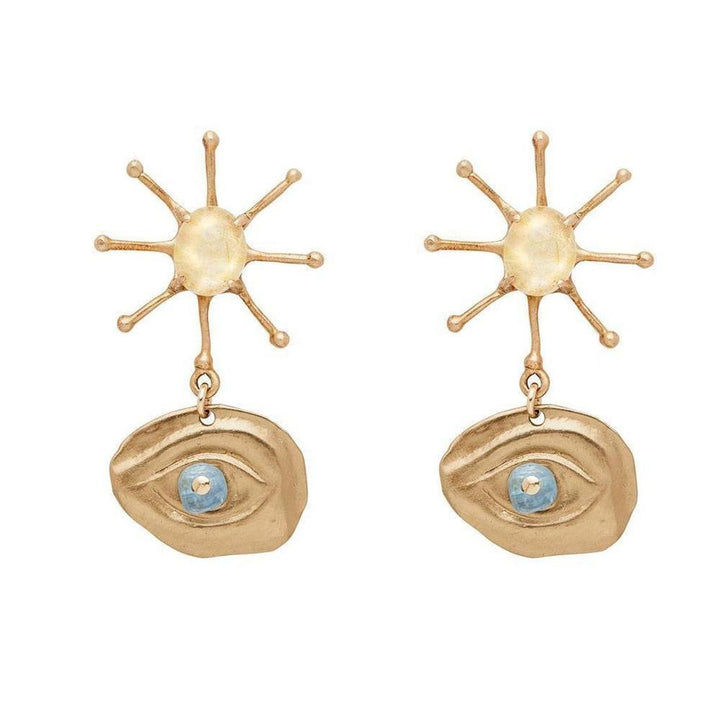 Gold Illumination earrings featuring sunburst and eye motif with blue gemstone accents.
