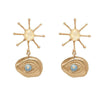 Gold Illumination earrings featuring sunburst and eye motif with blue gemstone accents.