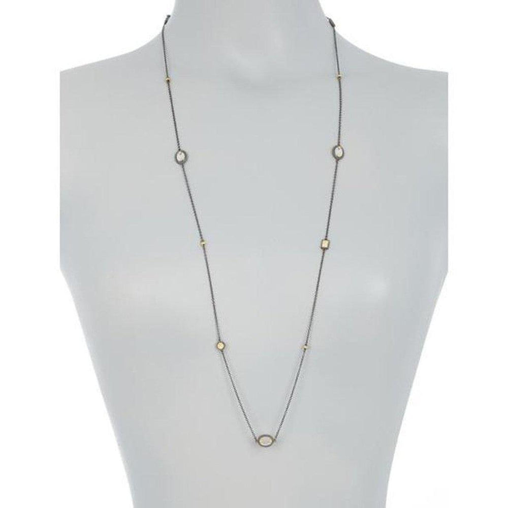 Long mother-of-pearl station necklace with dark metal chain and gold accents.