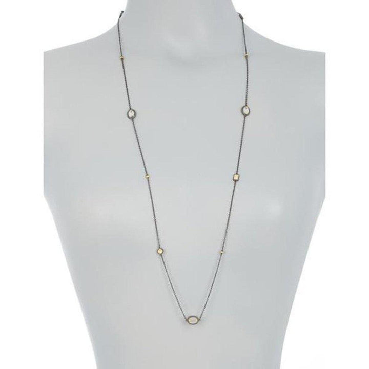 Long mother-of-pearl station necklace with dark metal chain and gold accents.