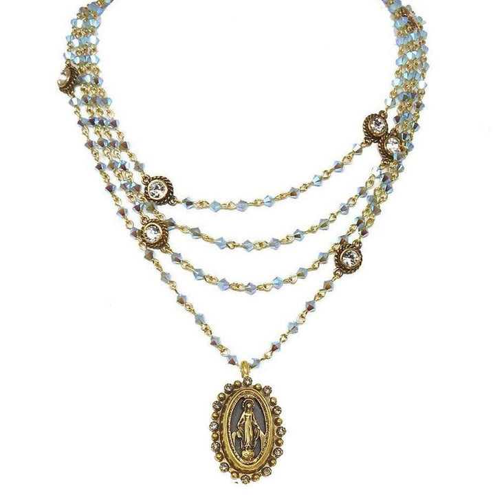 Layered iridescent blue crystal necklace with gold accents and Madonna medallion.