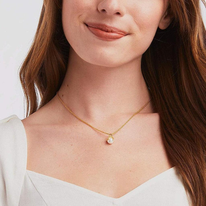 Gold chain necklace featuring a delicate pearl pendant.