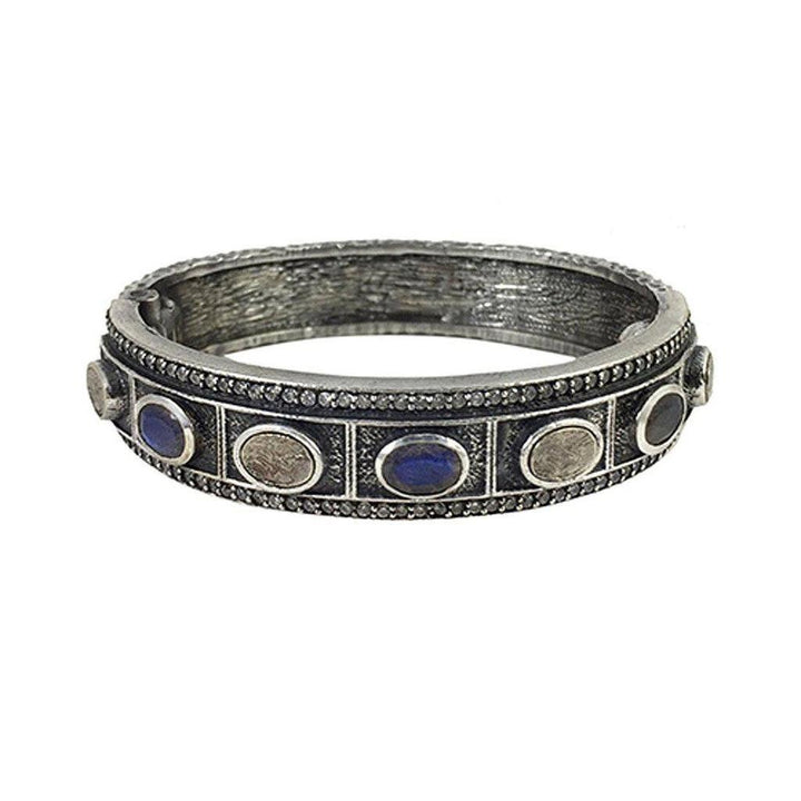 Silver hinged bangle bracelet featuring blue and gray gemstone accents.
