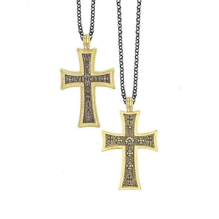 Ornate gold and dark metal cross pendants on black chains; one features an inscription.