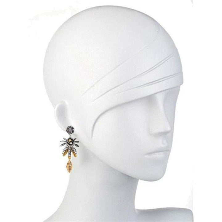 Mixed-metal leaf-shaped dangle earrings on a mannequin.