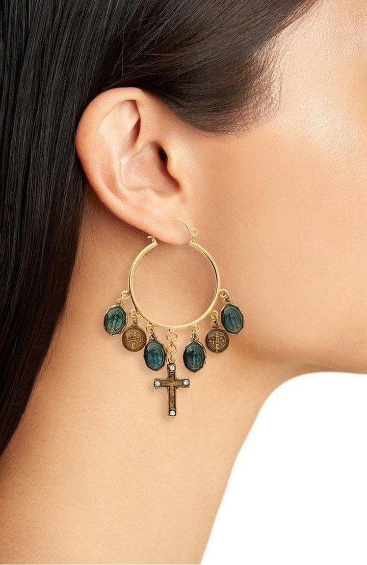 Gold hoop earrings adorned with dark green and gold charms, and a small cross pendant.
