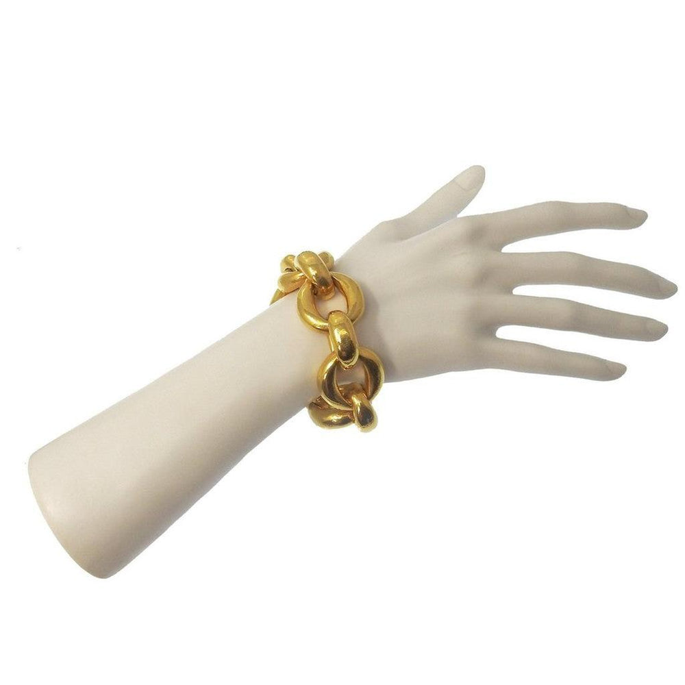 Gold link bracelet on mannequin wrist, chunky chain design.