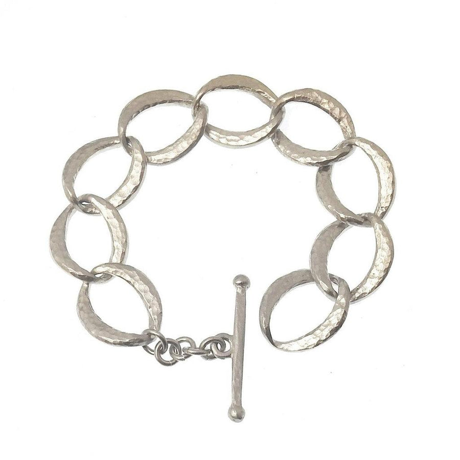 Silver link bracelet with hammered texture and toggle clasp.