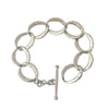 Silver link bracelet with hammered texture and toggle clasp.