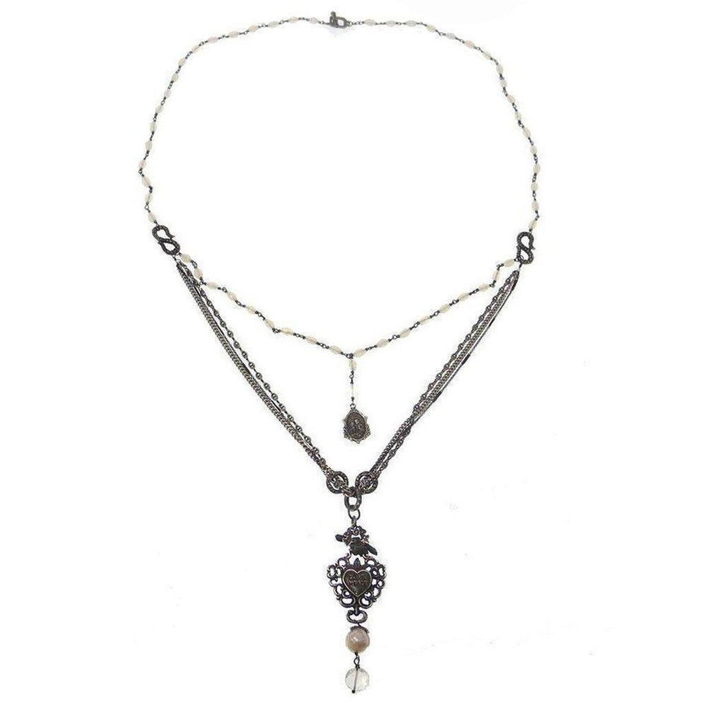 Layered necklace featuring pearl beads, metal chains, and ornate heart pendant.