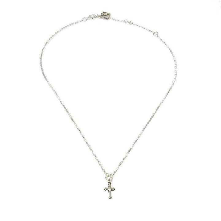 Dainty silver cross pendant necklace on a delicate chain.