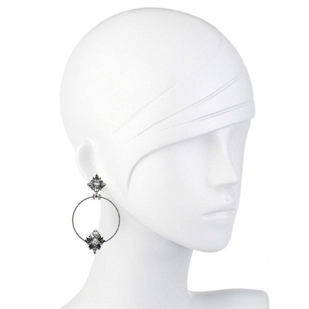 Silver hoop earrings adorned with sparkling crystal accents, shown on a mannequin.