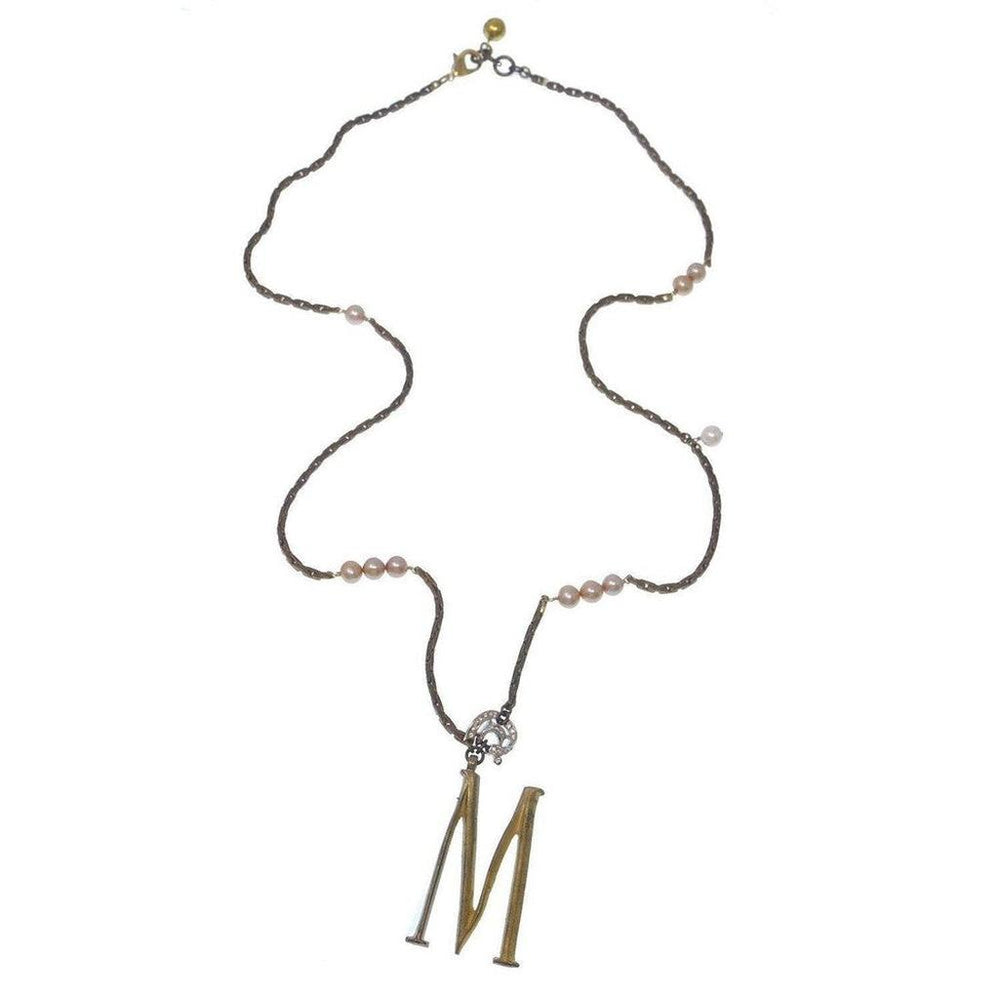 Gold initial M pendant necklace on brown chain with delicate pearls.