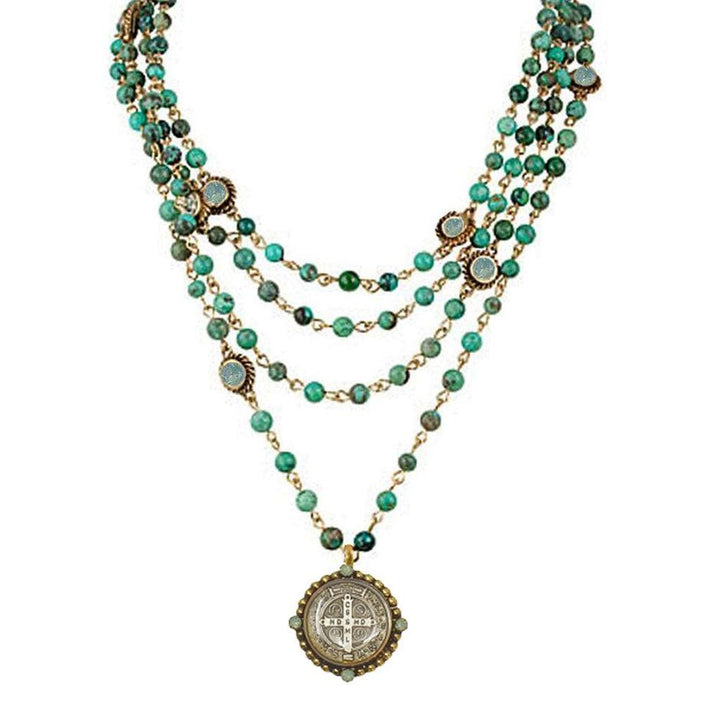Multi-strand turquoise bead necklace with antique coin pendant.