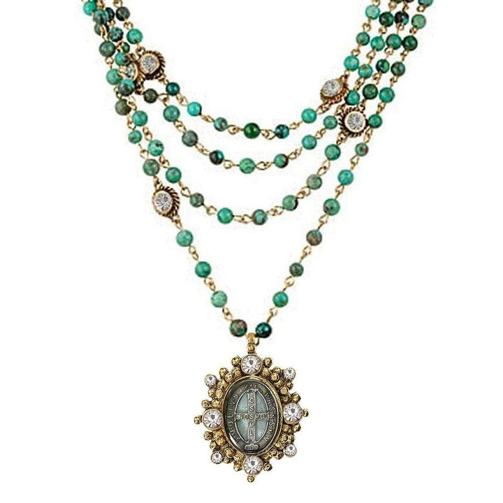 Multi-strand turquoise bead necklace with gold accents and a detailed pendant.