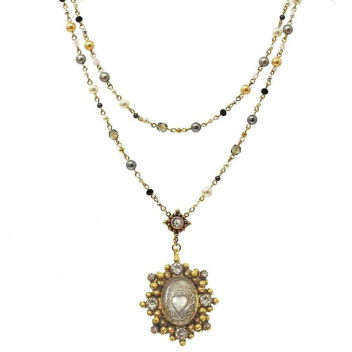 Elegant layered pearl and gemstone necklace with a heart-shaped pendant.