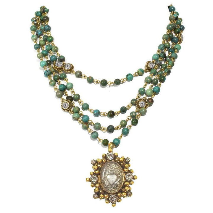 Layered turquoise bead necklace with gold accents and a detailed silver pendant.