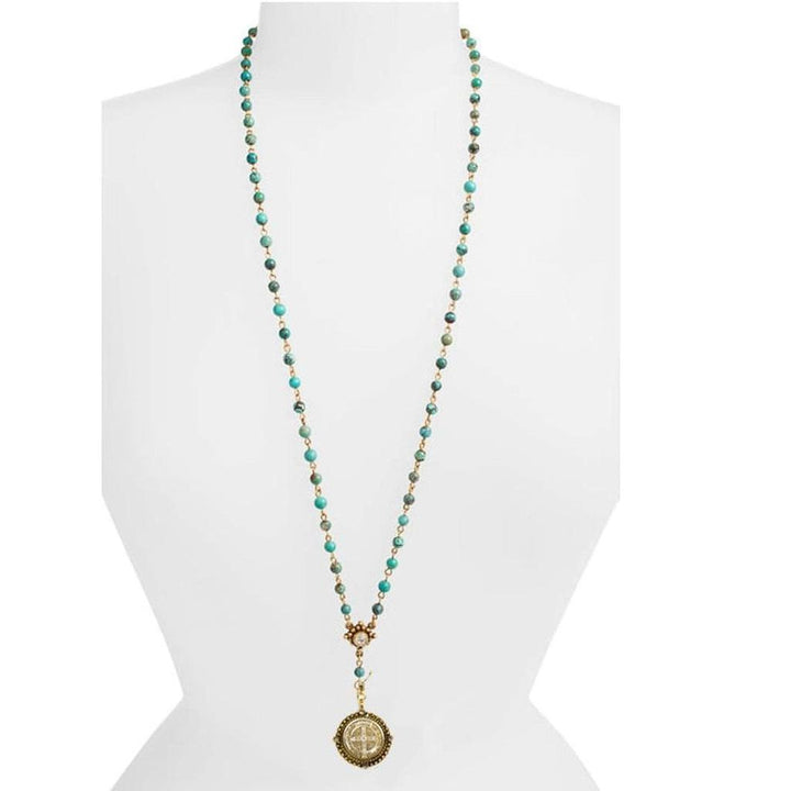 Long turquoise beaded necklace with gold accents and medallion pendant.