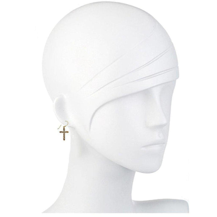 Gold cross earrings on a mannequin, showcasing detailed design.