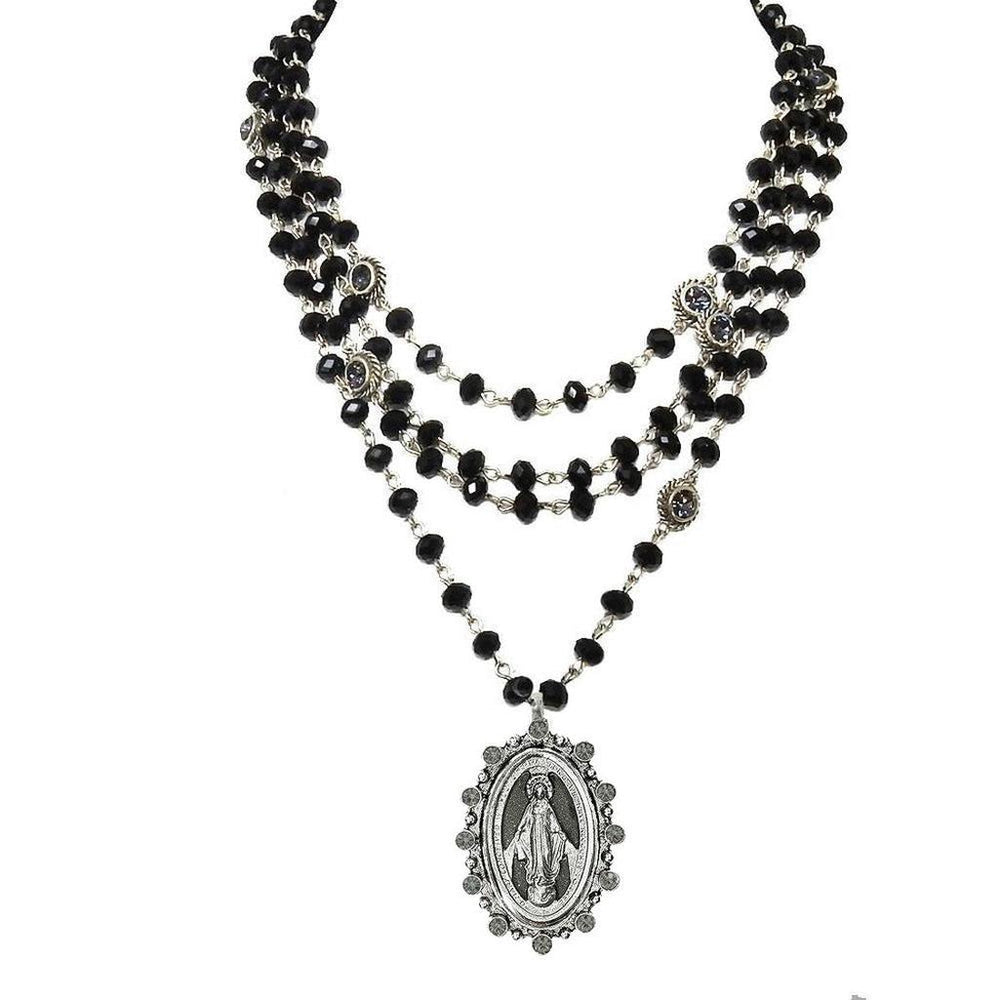 Layered black glass bead necklace with a silver Virgin Mary pendant.