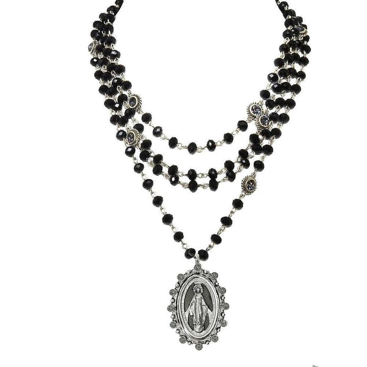 Layered black glass bead necklace with a silver Virgin Mary pendant.
