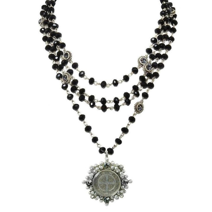 Layered black crystal bead necklace with a silver medallion pendant.