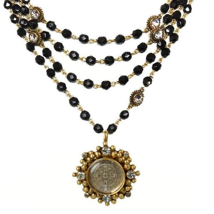 Black glass bead necklace with gold accents and a detailed antique coin pendant.