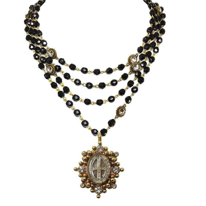Multi-strand black beaded necklace with gold accents and a detailed antique pendant.