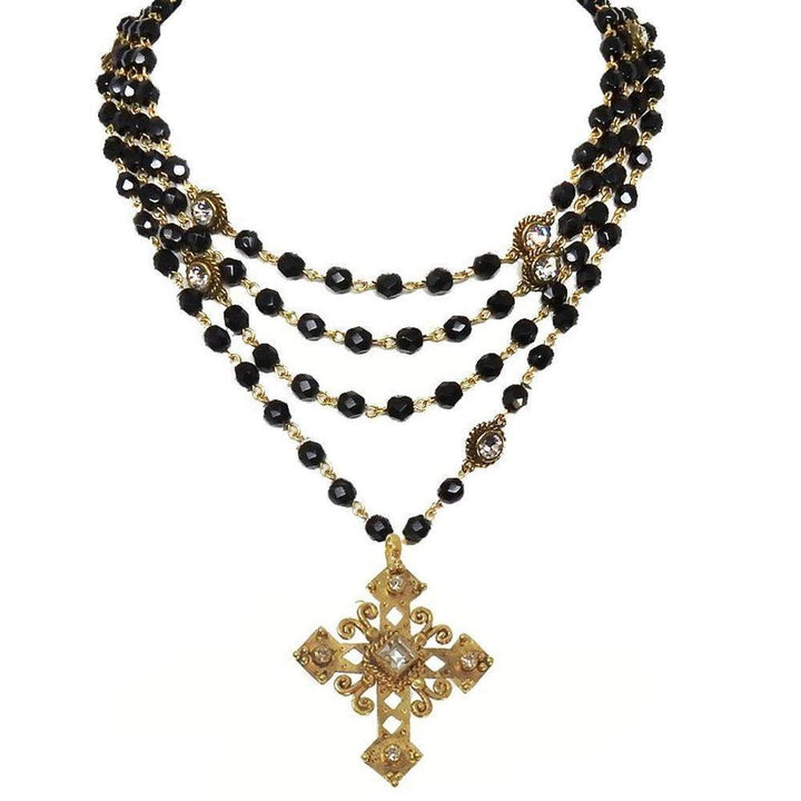 Black onyx and gold multi-strand necklace featuring a detailed cross pendant.