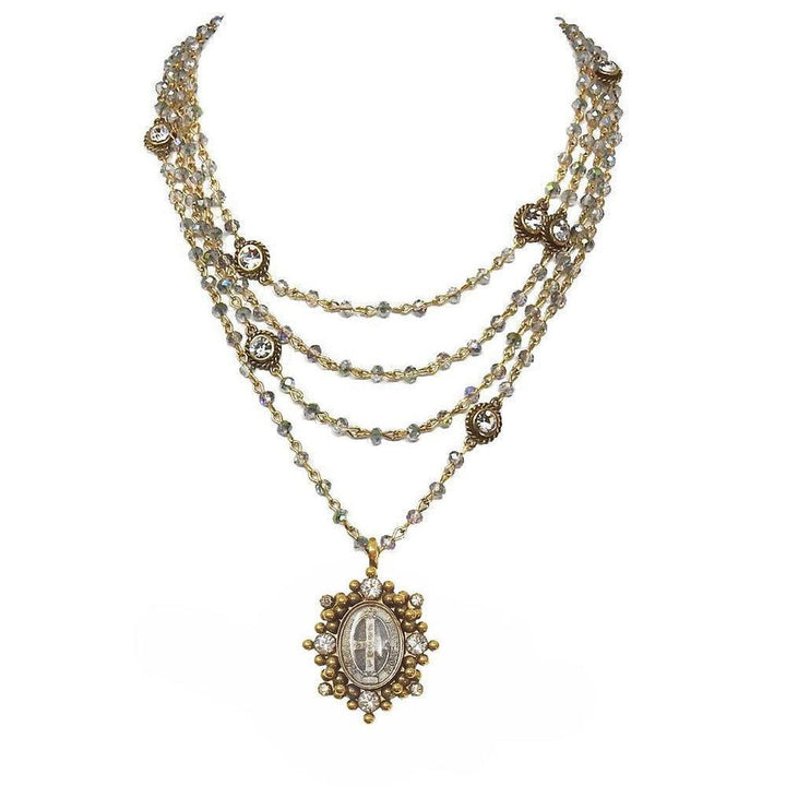 Multi-strand necklace with gold accents and crystal beads, featuring an ornate pendant.