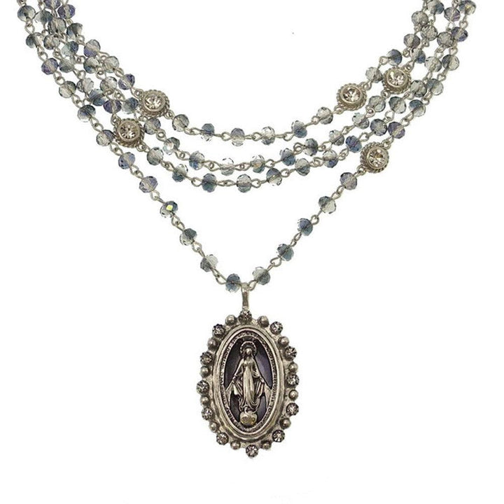 Multi-strand necklace featuring a silver Virgin Mary pendant, accented with blue crystals.