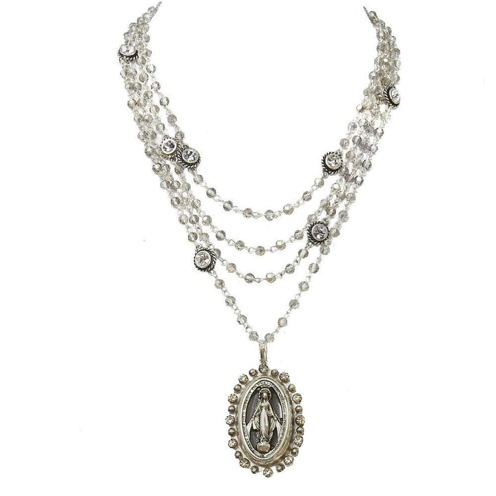 Layered silver necklace with clear crystal beads and a Virgin Mary pendant.