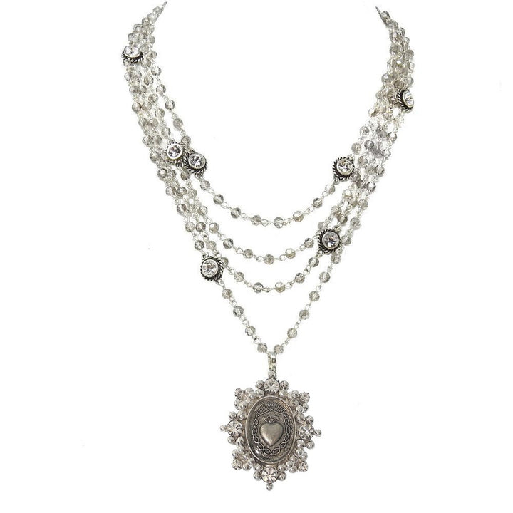 Multi-strand necklace with crystal beads and a silver heart pendant.