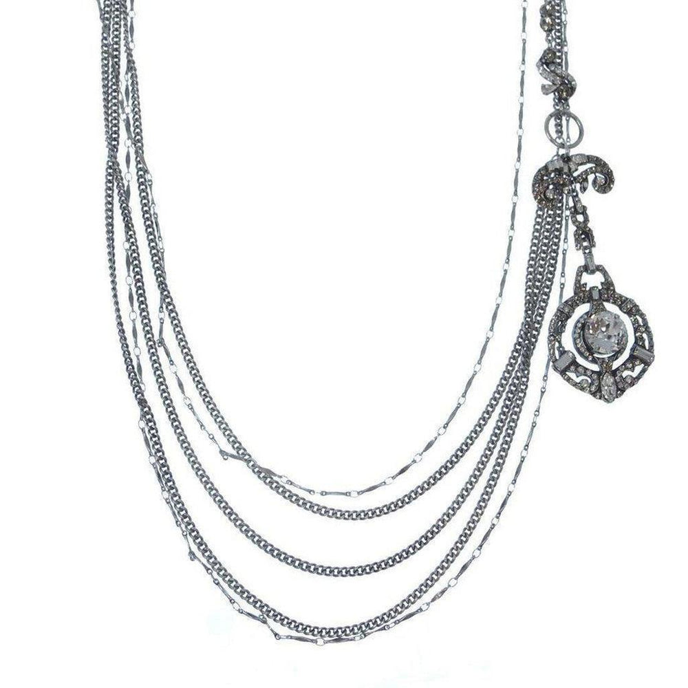 Silver multi-strand necklace with ornate pendant and clear cabochon stone.