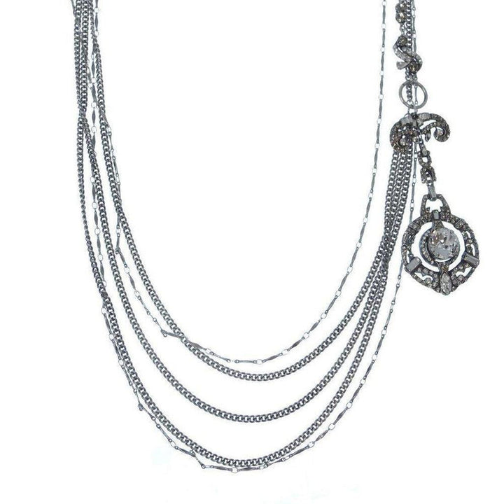 Silver multi-strand necklace with ornate pendant and clear cabochon stone.