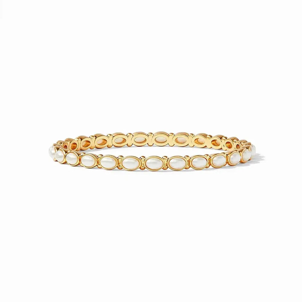 Gold bangle bracelet adorned with oval-shaped white pearls.