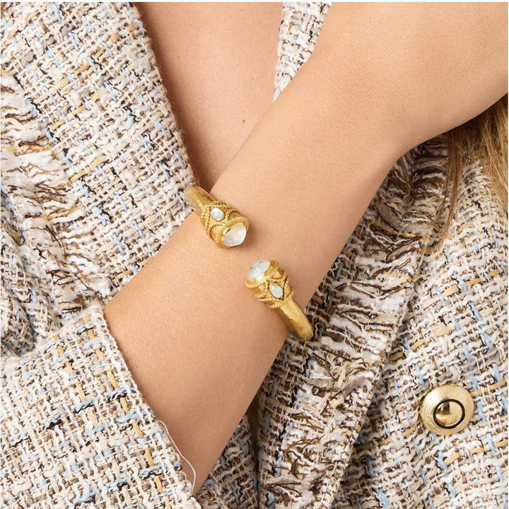 Gold cuff bracelet adorned with moonstone accents, shown on a model's wrist.